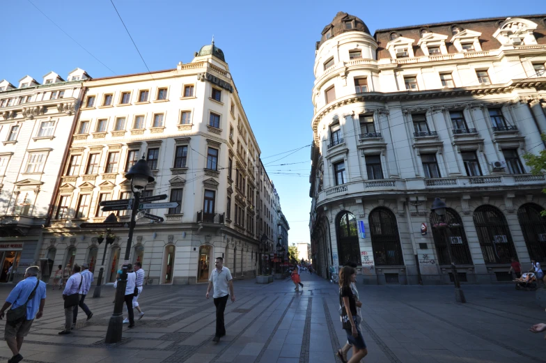 the building has many windows and many people are walking around