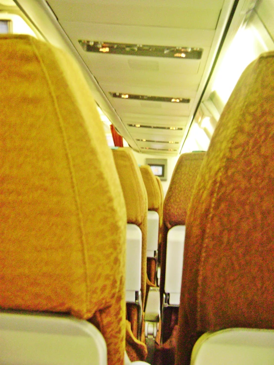 seats are empty in an airplane with the overhead lights