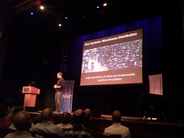 a person on a stage giving a presentation to an audience