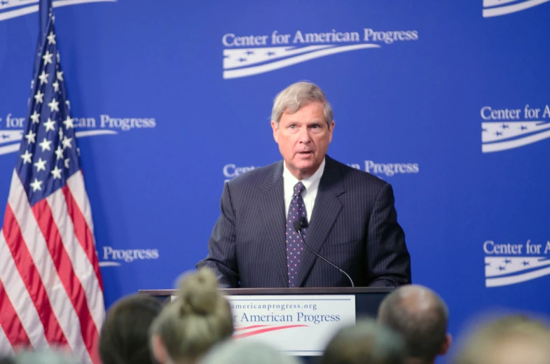 a speaker at a podium during a press conference