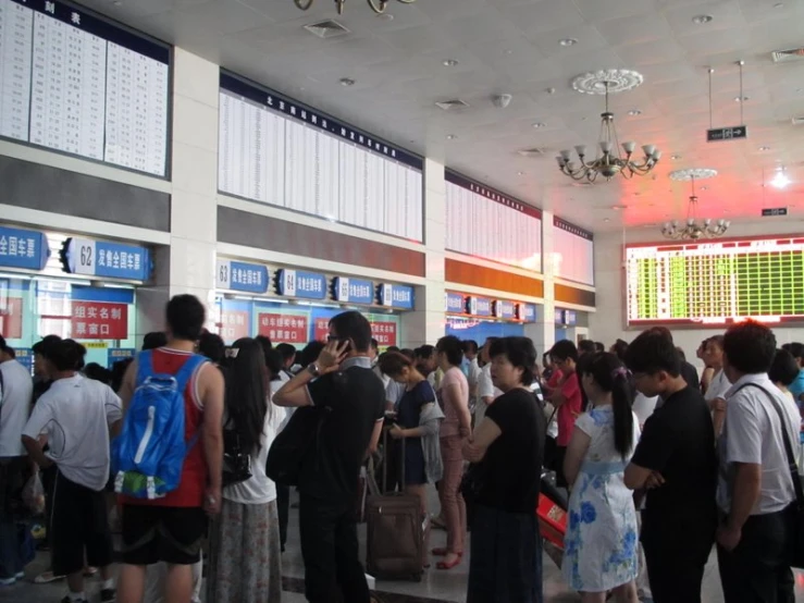 several people waiting in line for luggage