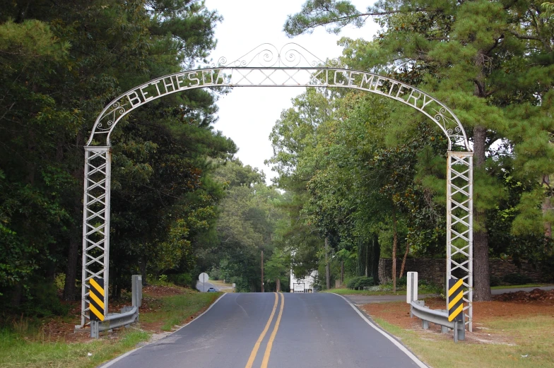 an old fashion entrance with arched white iron gates