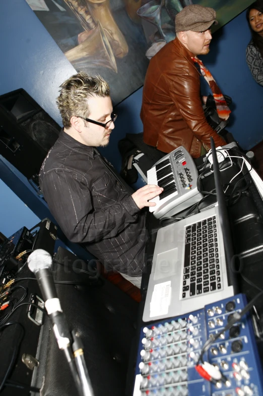 a man in a black shirt using a laptop on a table