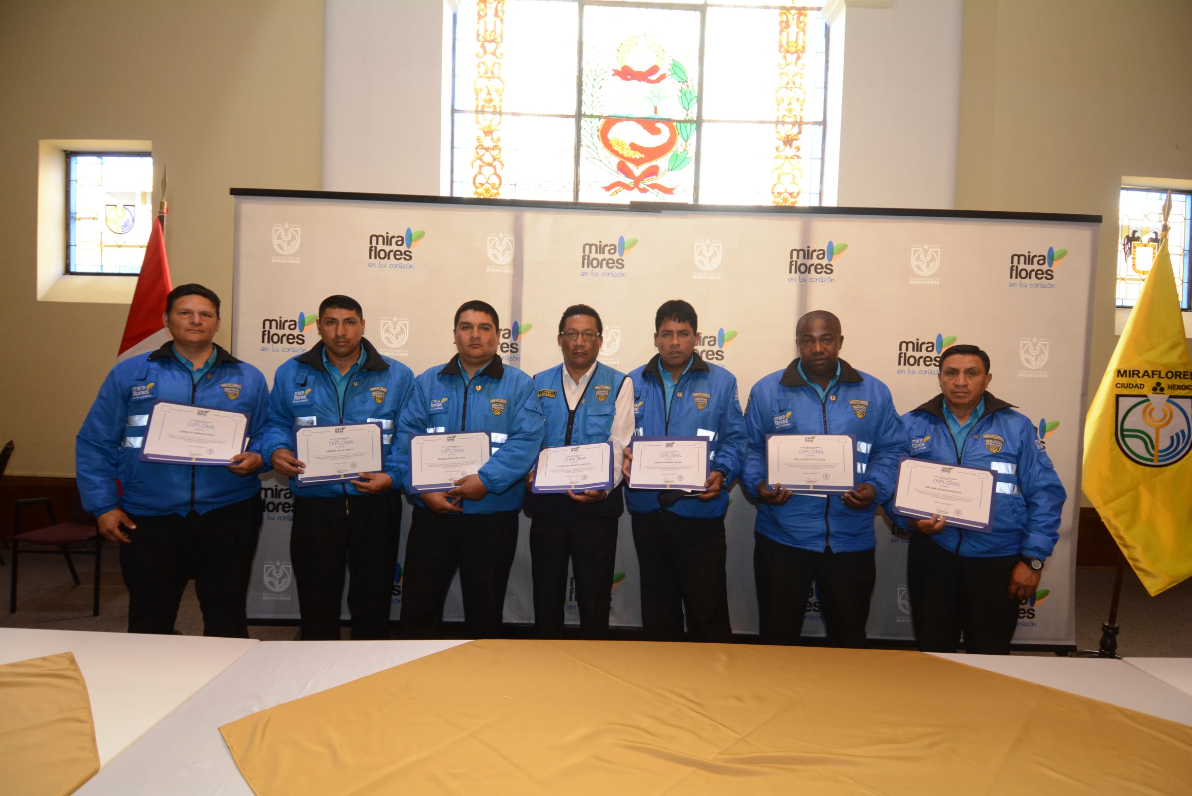 seven men in blue jackets with white paper