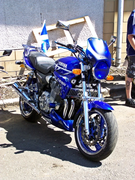 the motorcycle is parked near another person and his shadow