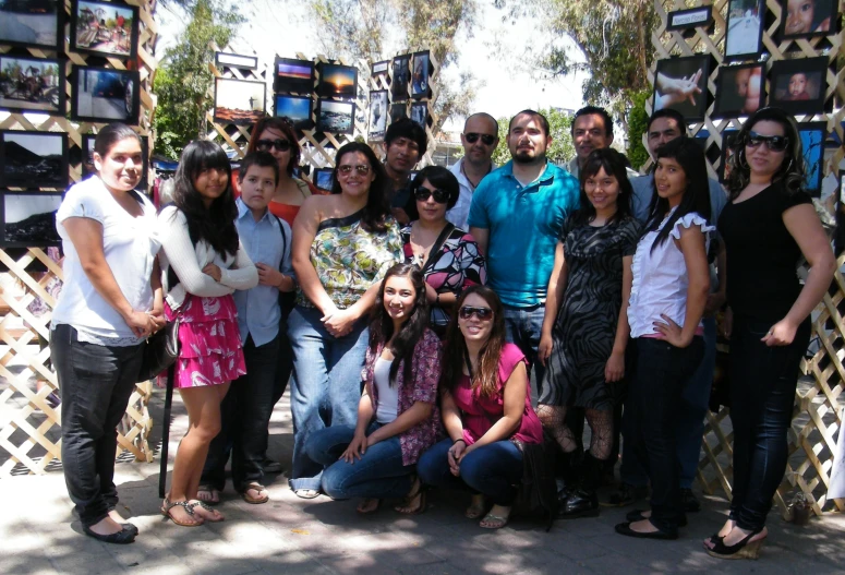 people posing in front of frames of pictures