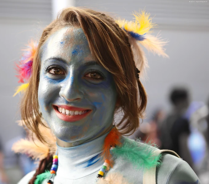 a woman in costume wearing feathers painted on her face