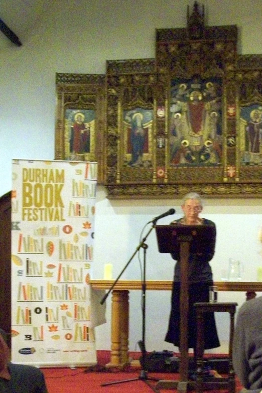 a man stands behind a podium in front of a microphone