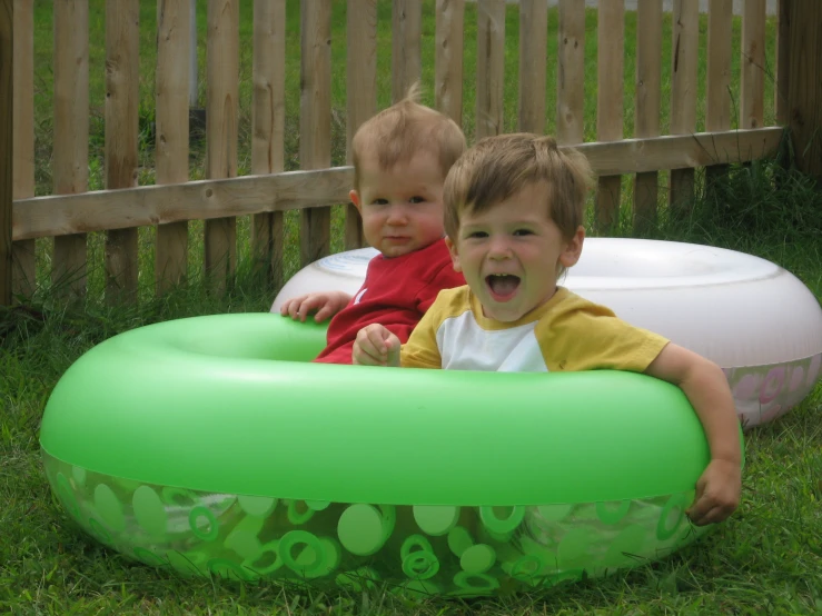 a couple of s sitting on top of a big green toy