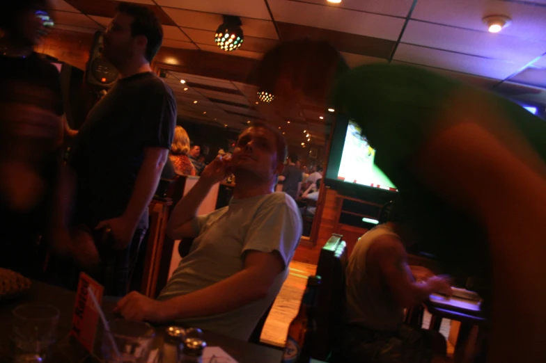 people standing in a restaurant next to television screens