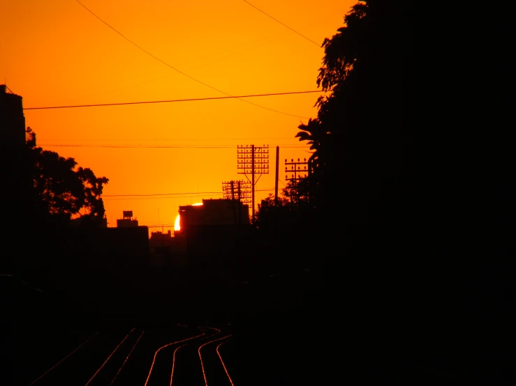 some wires are on a line and the sun is setting