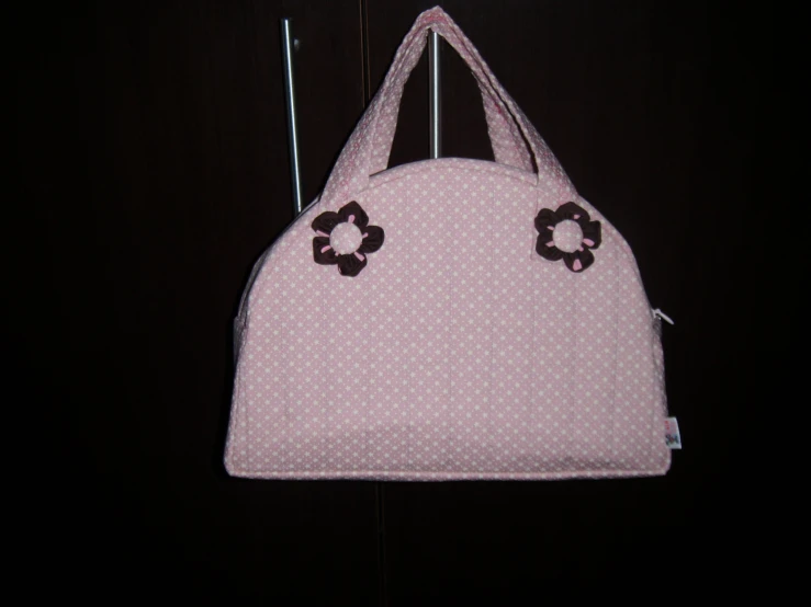 a white purse with pink polka dots and flowers