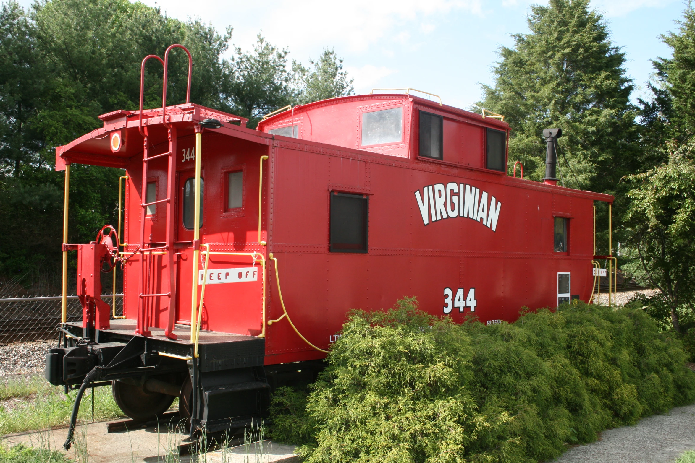 a red train car sits parked in a lot