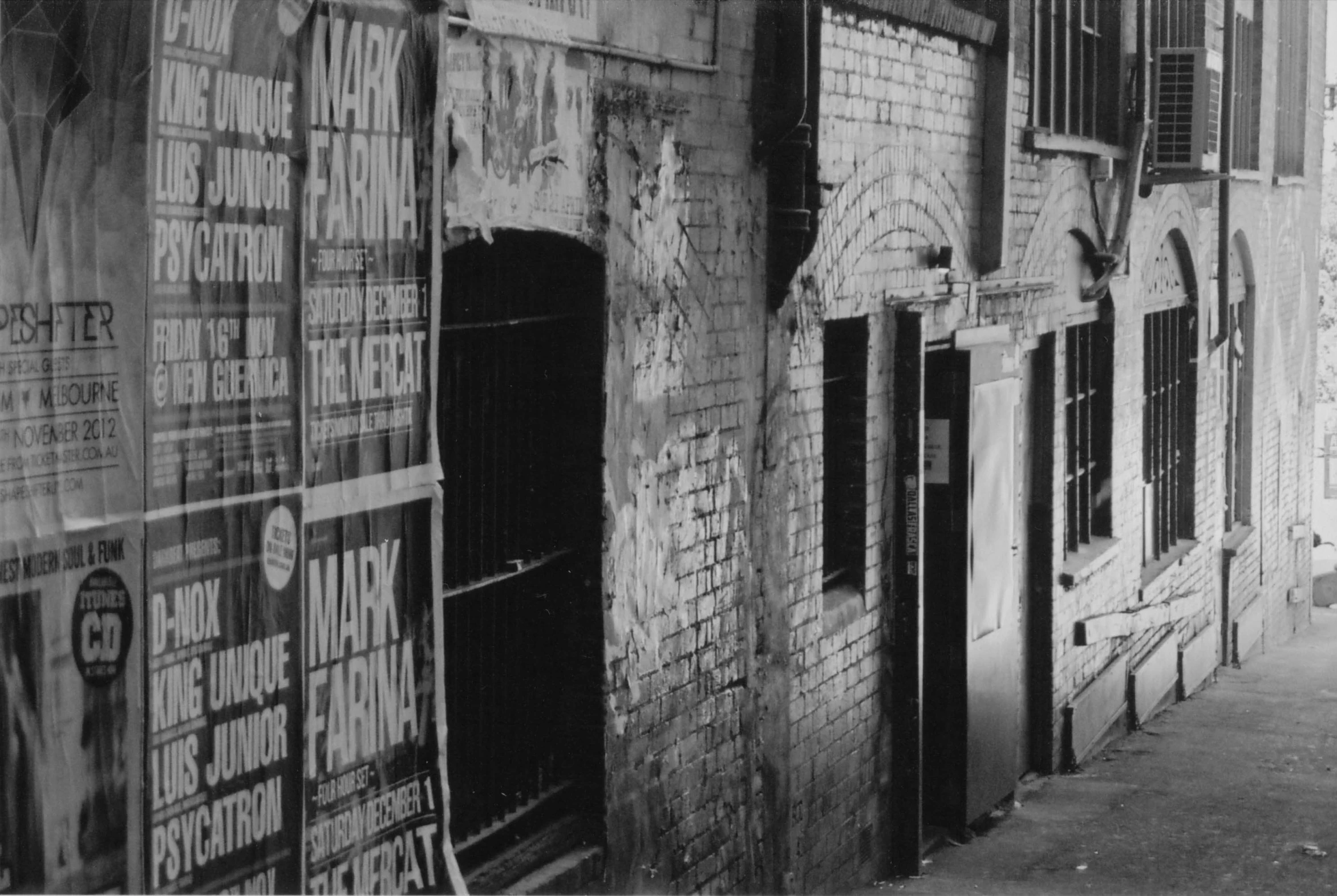 a black and white po of a brick building with graffiti on it