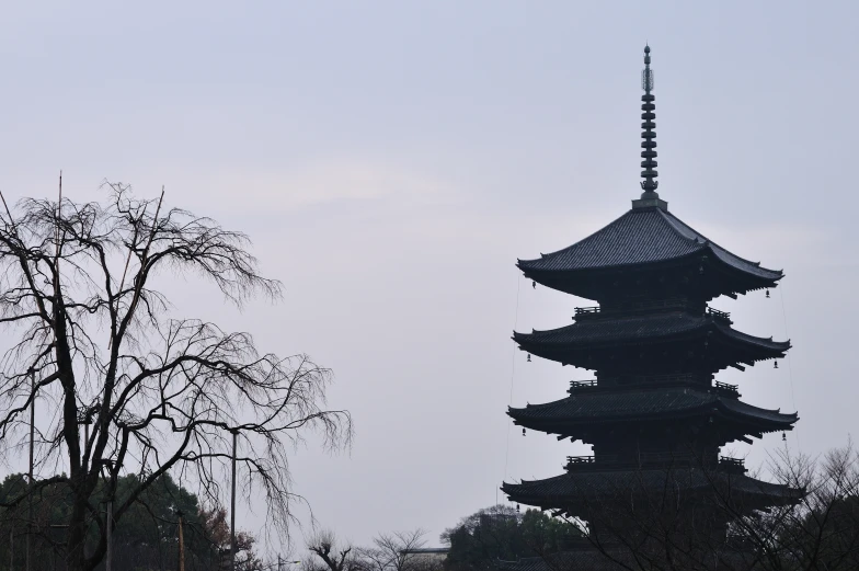 two people walking in front of a tall pagoda