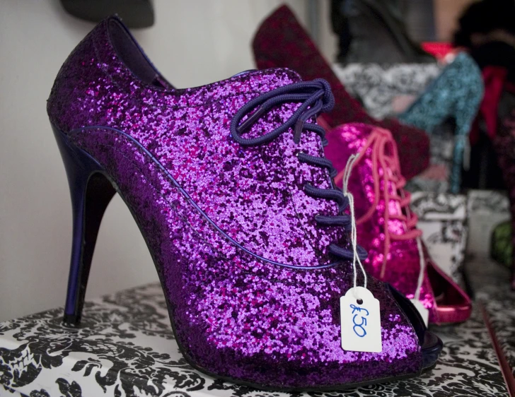 a purple pair of shoes is on a floral cushion