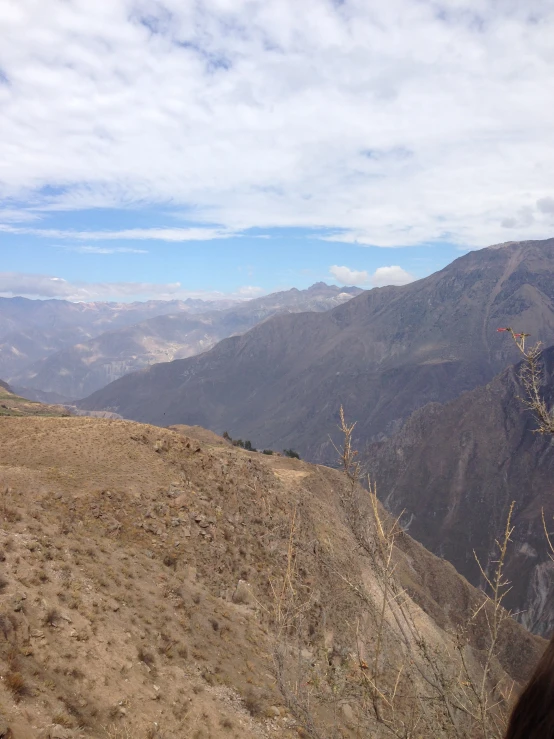 a man standing on top of a hill near a very tall mountain