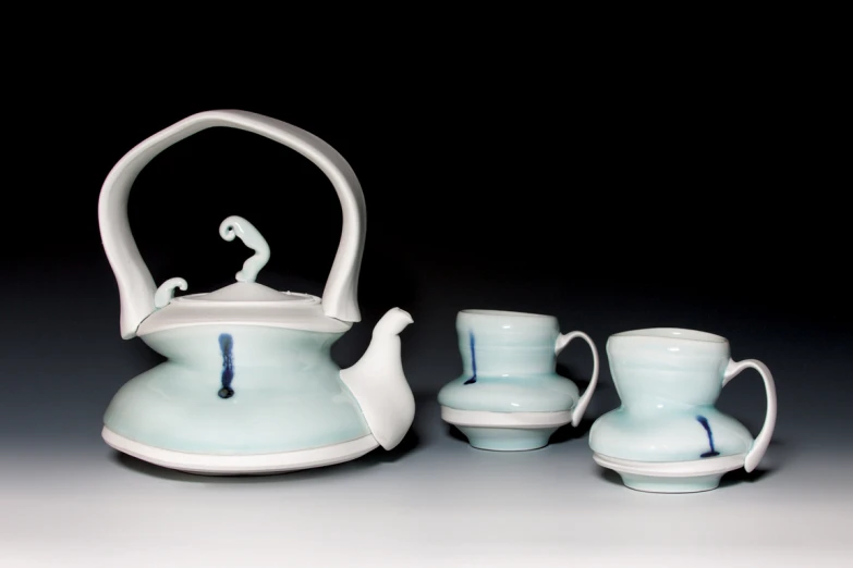 a white tea set on a table in the dark