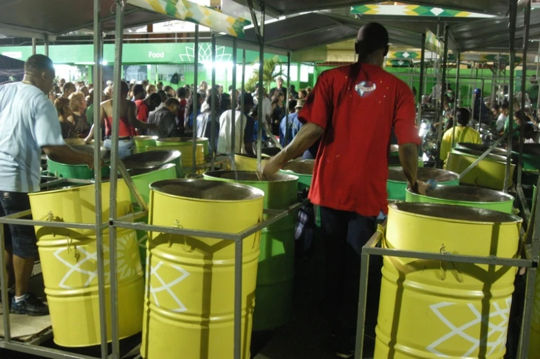 a man standing near a large yellow barrel filled with water