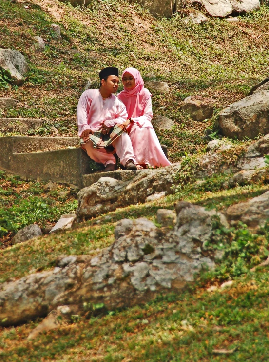 two people in colorful outfits sit on the ground