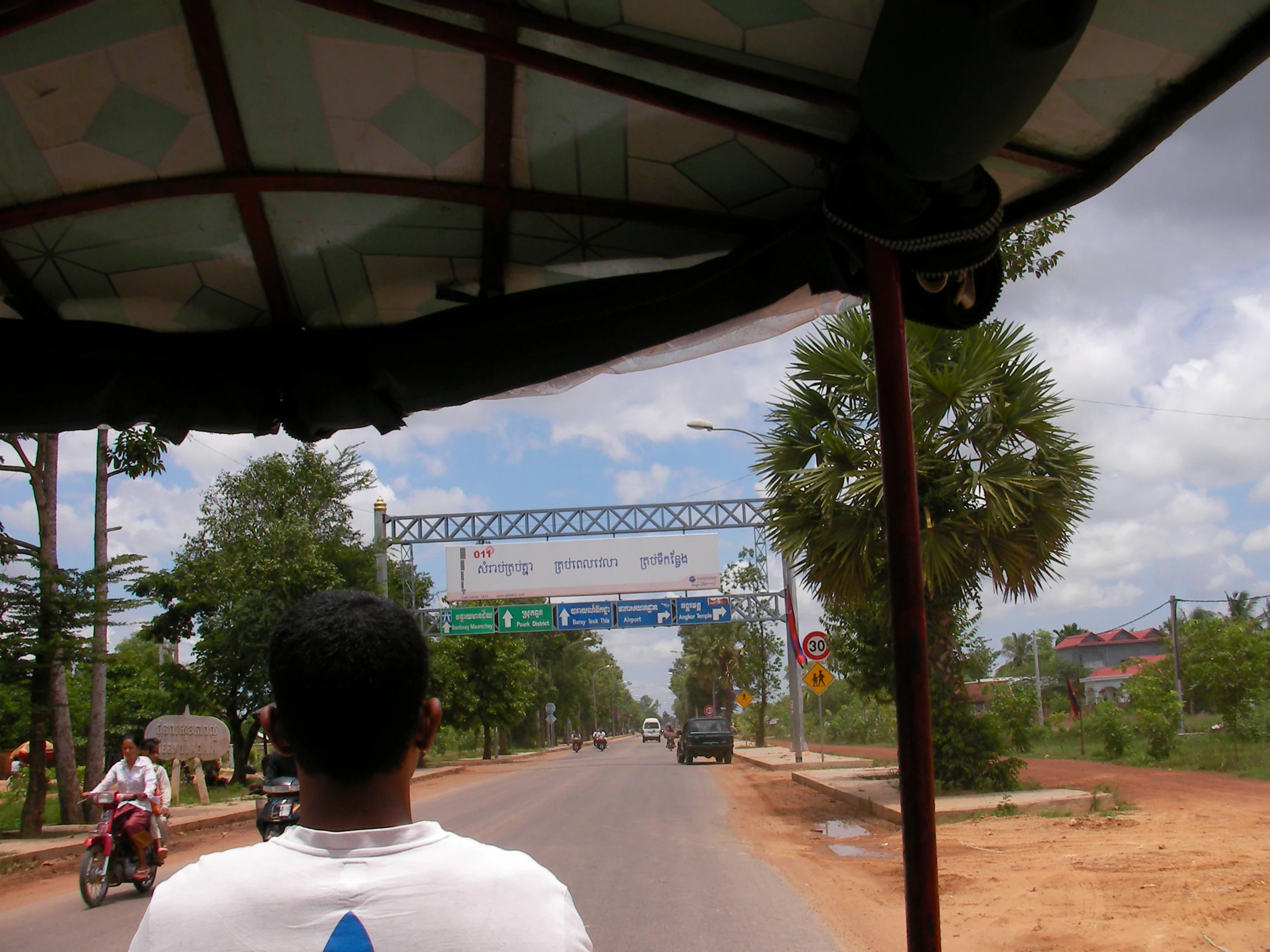 a man on his motor bike on the road near a bridge