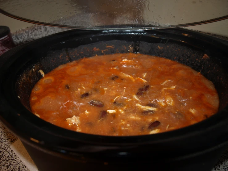 a crock pot that is filled with soup on the counter