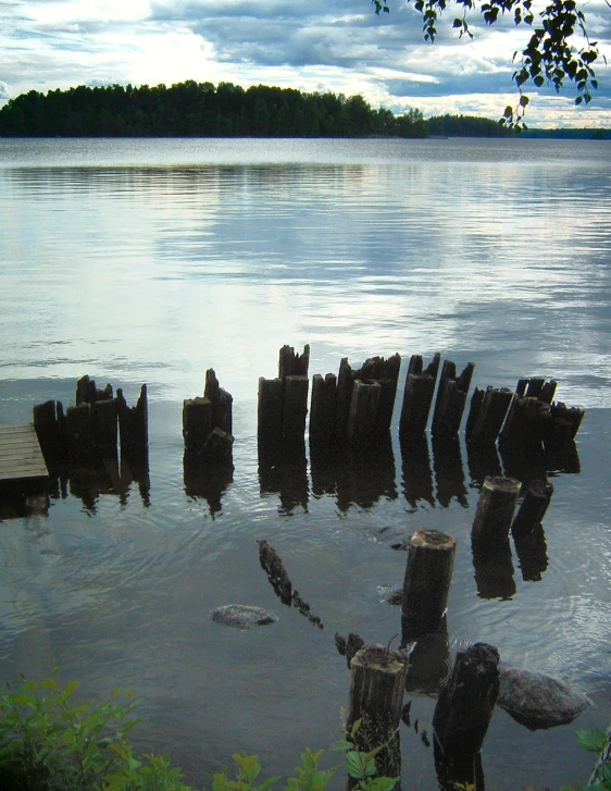 a large body of water with a few pieces of wood sticking out of it