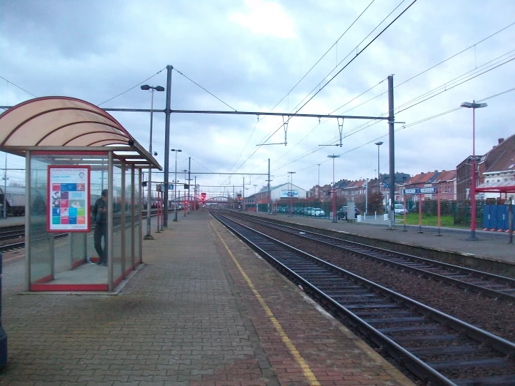 a red stop sign at a train station with several railroad tracks in front of it