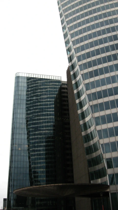 two skyscrs are in the foreground as an airplane flies by