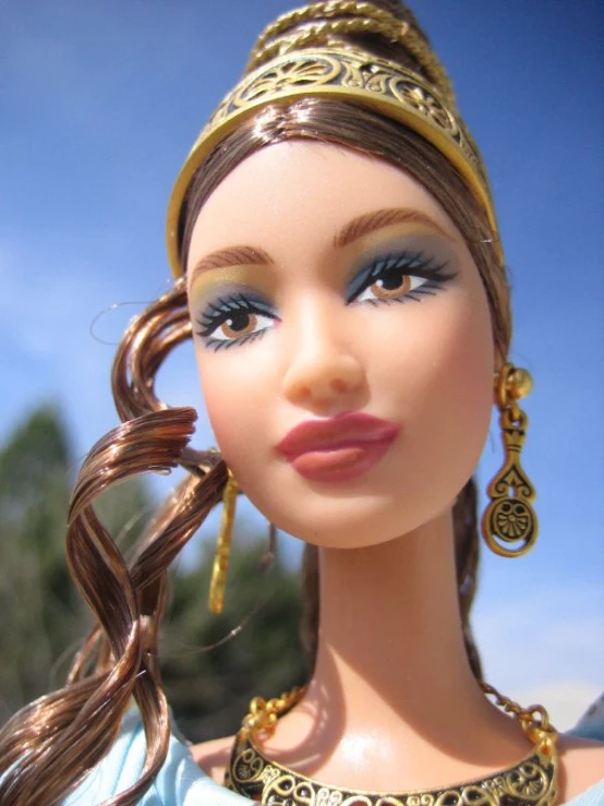 a doll with her hair curled back and wearing an elaborate jewelry and a gold necklace