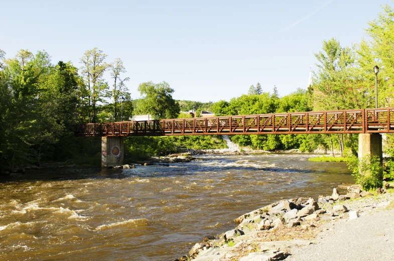 a bridge with a truck crossing it over a river