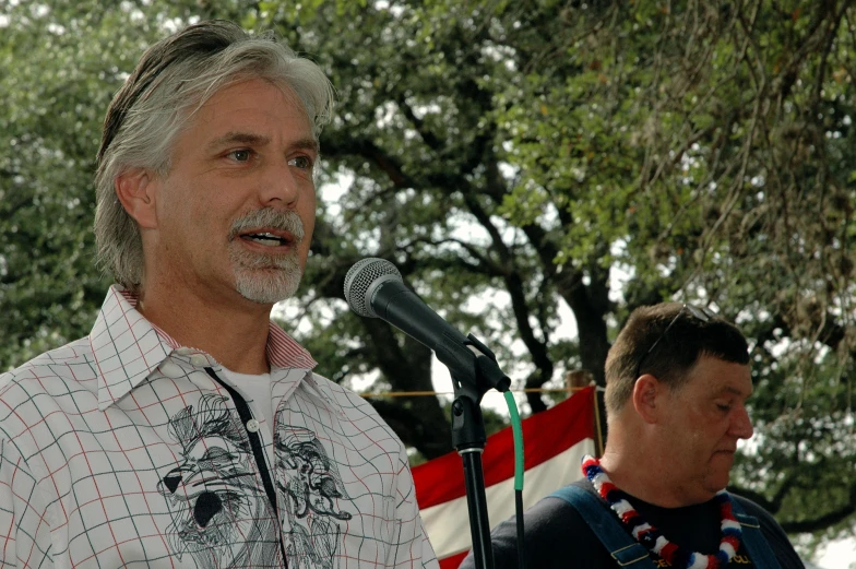 two men standing at podiums in front of a microphone