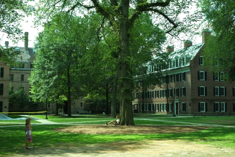 large brick building surrounded by trees on grassy area
