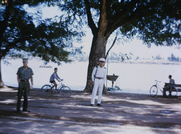 a couple of men standing next to a tree