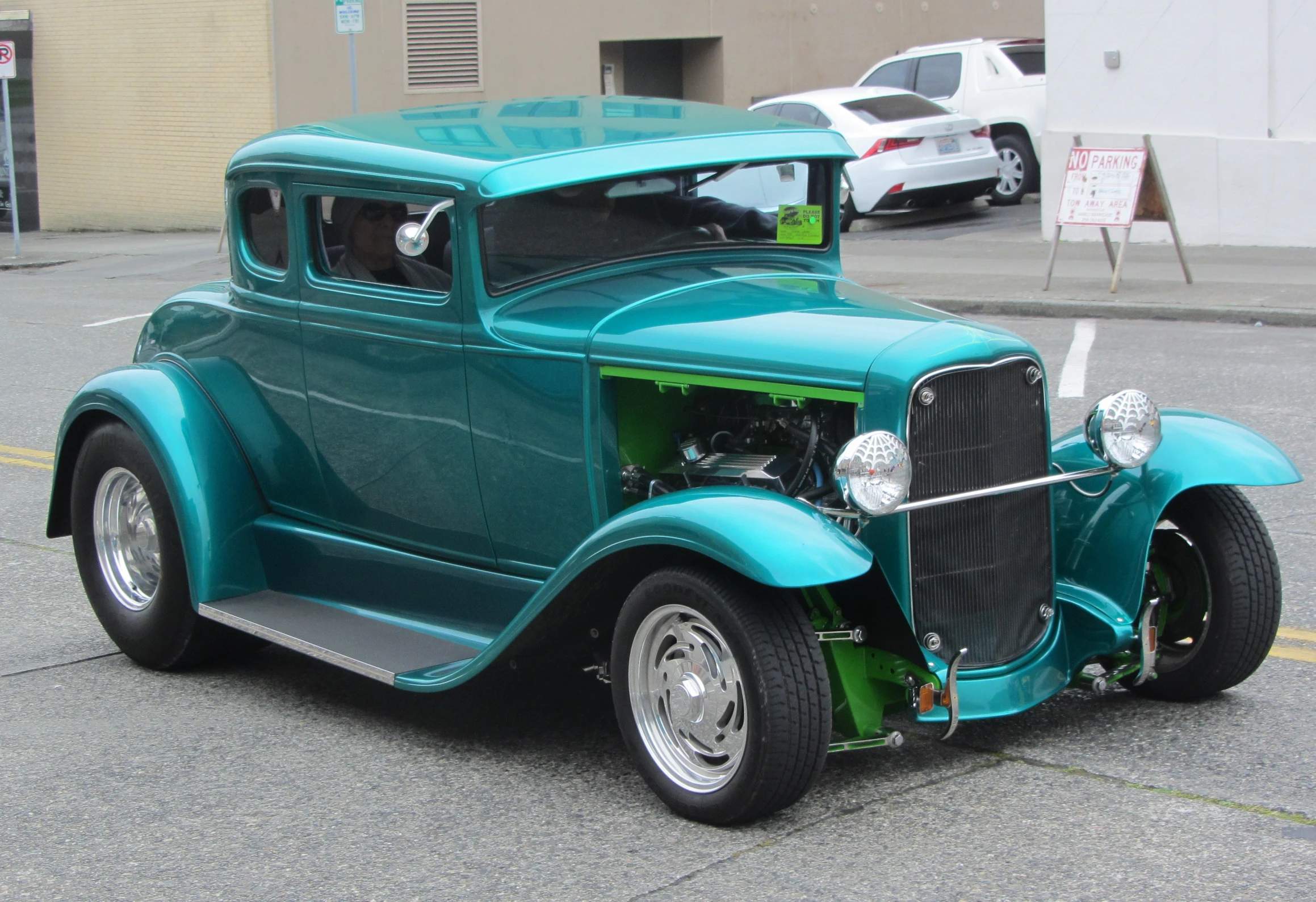 an antique green car in a parking lot