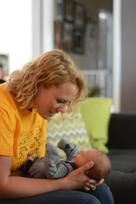 the woman is holding a baby doll and smiling