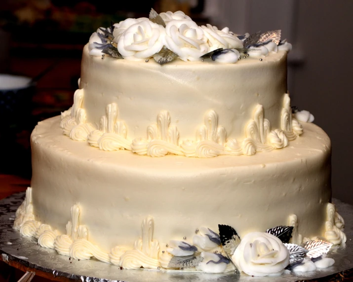 a wedding cake with fresh cream frosting roses