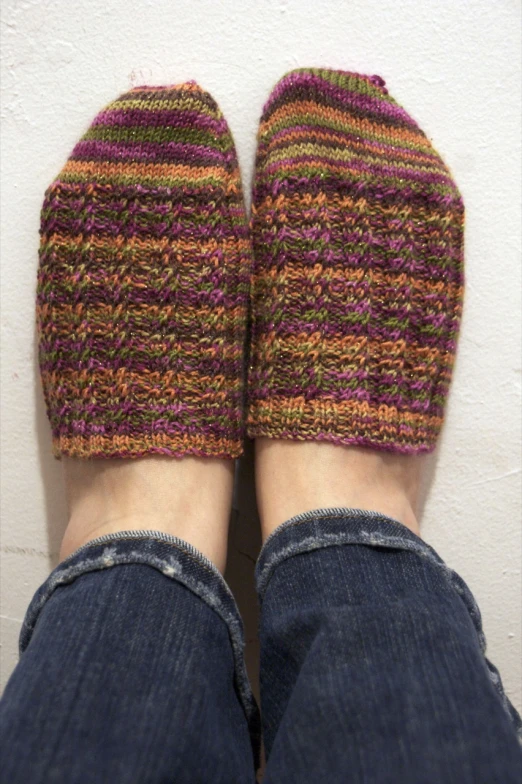 a pair of shoes that are knitted and being held up