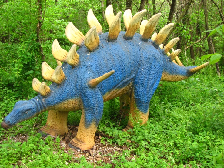a blue toy tri - trisaurus walking through a forest
