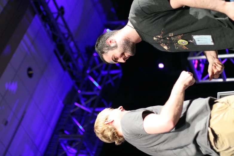 a couple of men shaking hands on stage