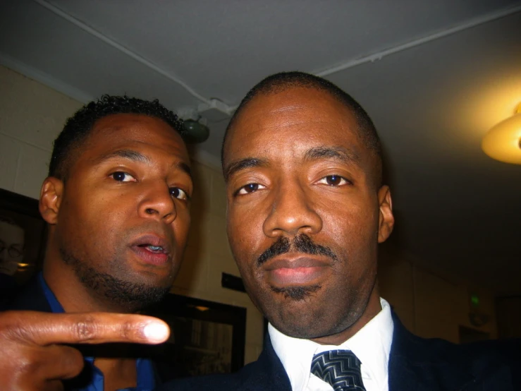 two men in suits posing for the camera