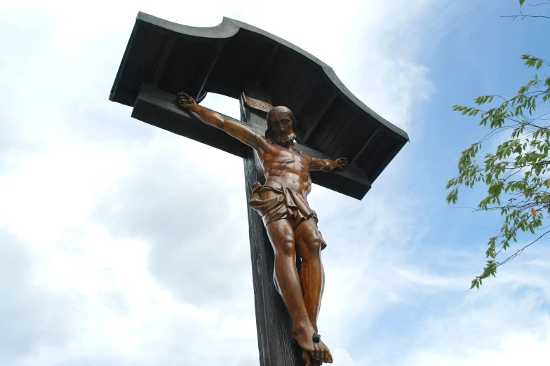 a cross with a statue of a crucifix and cross hanging on it