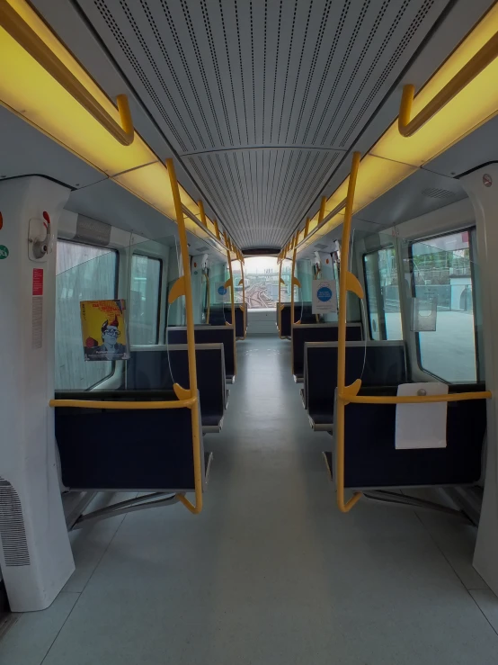 the inside view of a train with its yellow rails and seats