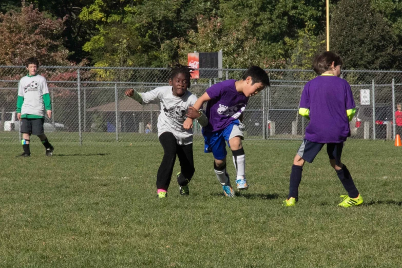 three boys and an soccer ball on a field