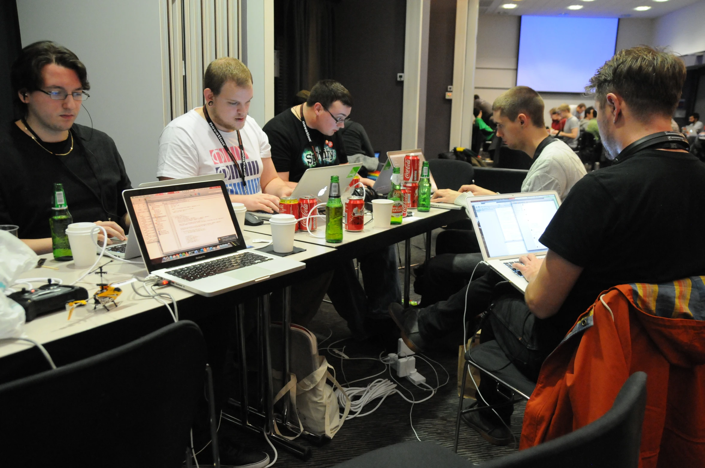 several people are sitting at tables using laptops