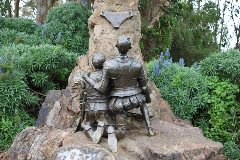 a metal statue sitting on top of a large rock