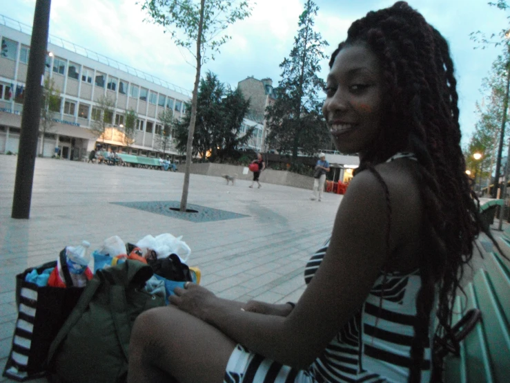 a smiling woman sitting on top of a bench