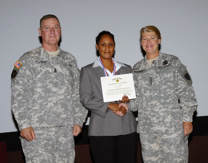 some soldiers in suits and one is holding a award