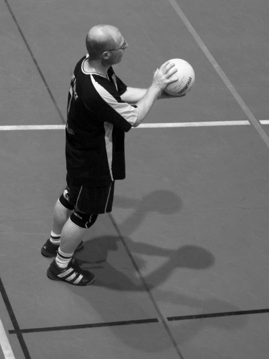 a man holding a ball on top of a tennis court