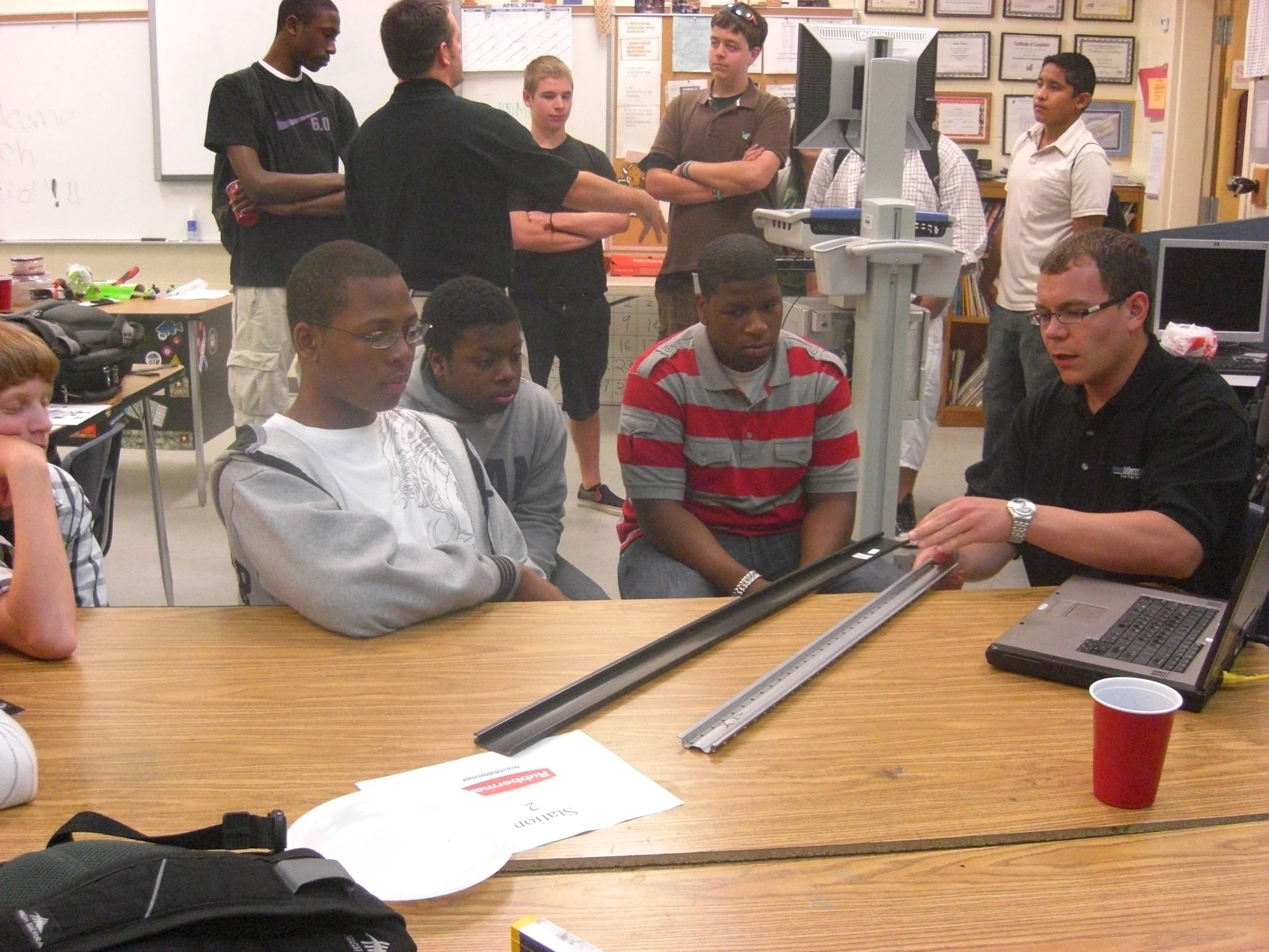 adults on cam sitting around a laptop computer